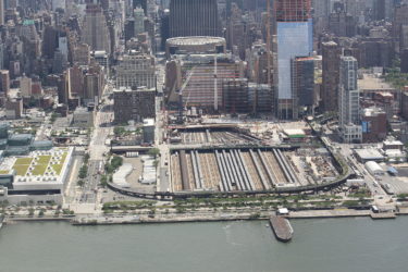 Aerial view of construction site along the Hudson River, with Midtown West buildings in the background