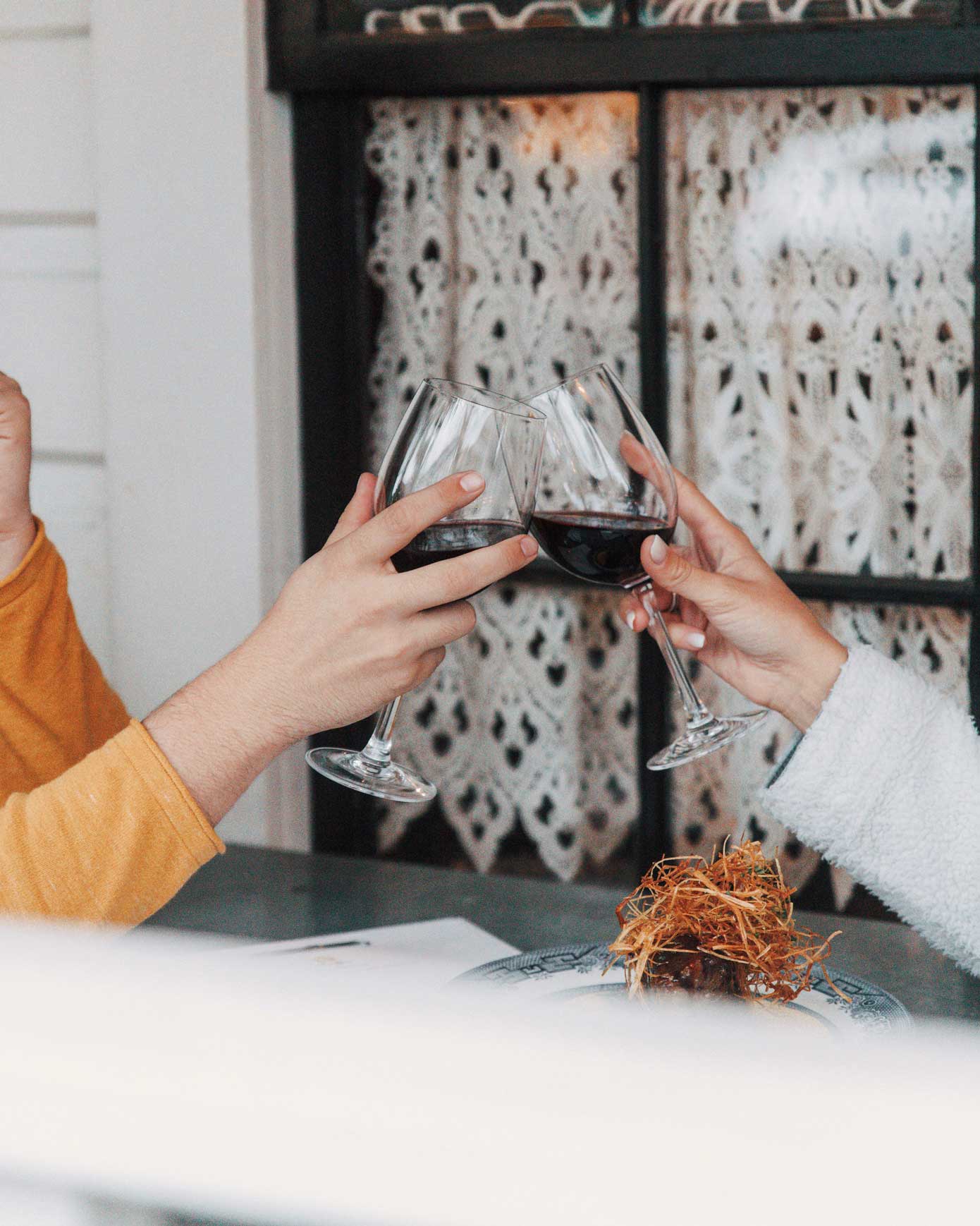 Two people clinking wine glasses