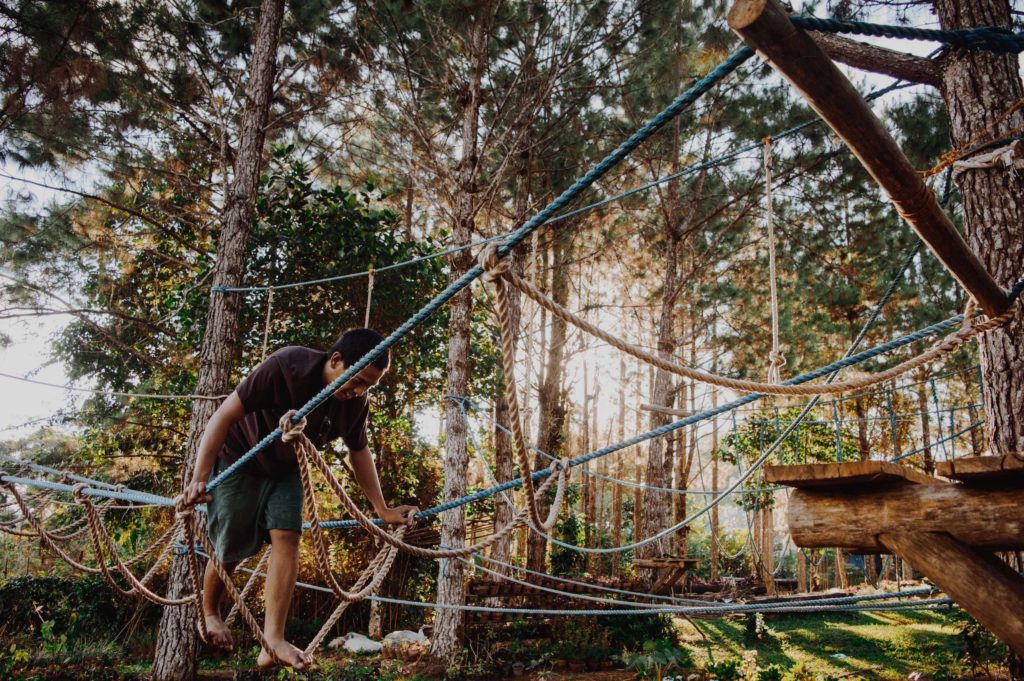 Man using an outdoor rope obstacle course